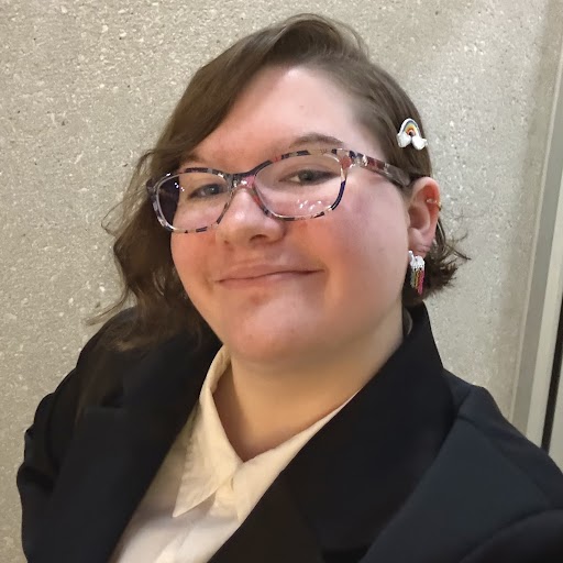 I'm wearing a suit! Also this is the most recent photo of me, with the nicer hairstyle and the new rainbow glasses.